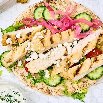 A sliced chicken filet in a Mediterranean-style pita