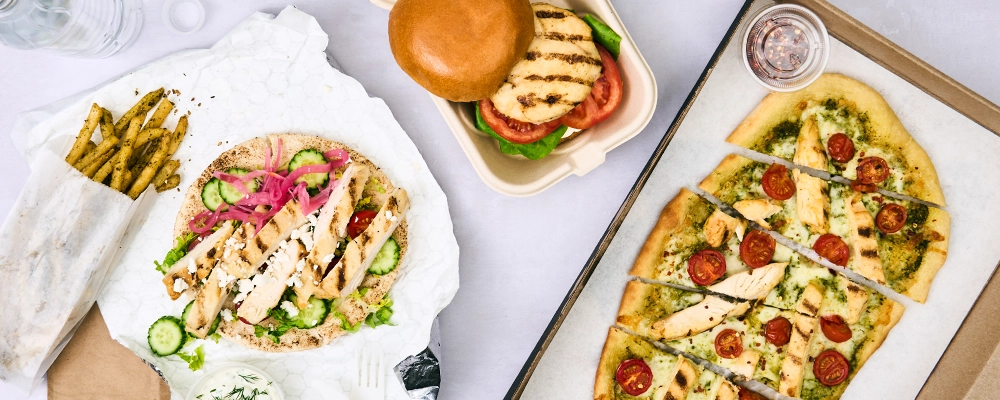 A top down image of a chilcken sandwich, flatbread, and pita wrap