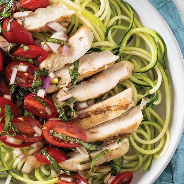 Grilled, sliced chicken atop a zoodle bowl