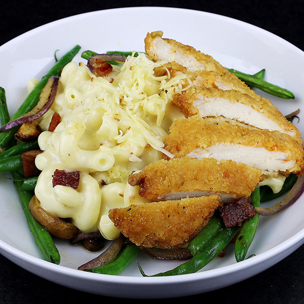 Plate of Mac N Cheese topped with a Breaded Chicken Filet