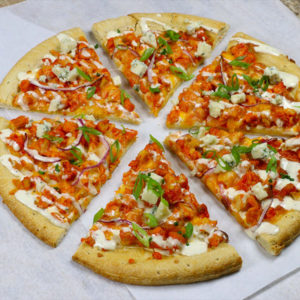 Pizza sliced in six pieces, topped with cheese, Buffalo-style sliced chicken, blue cheese crumbles, and onions