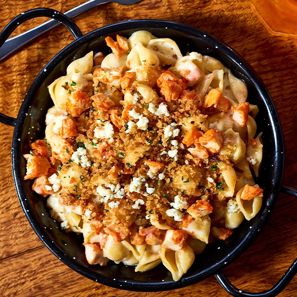 Mac n cheese topped with Buffalo-Style Diced Chicken and bread crumbs