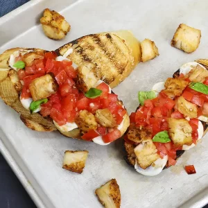 Bruschetta topped with mozzarella, tomatoes, and diced chicken