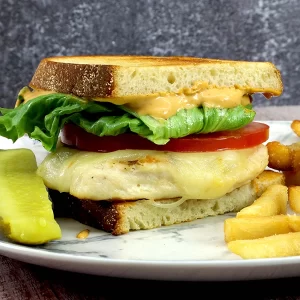 Chicken sandwich with tomato and lettuce on sourdough bread