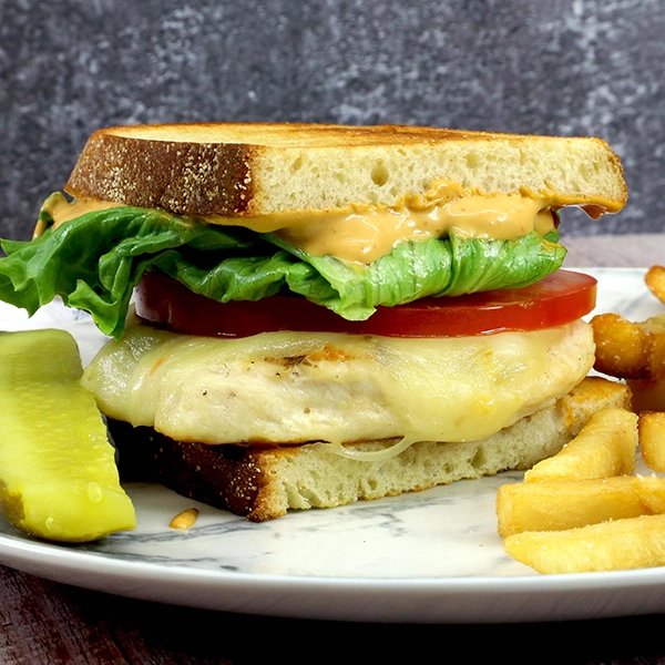 Chicken sandwich with tomato and lettuce on sourdough bread