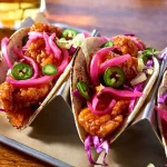 Boneless Wings with jalapenos and pickled onions in soft taco shells