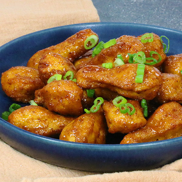 Boneless Chicken Drummies, glazed with honey garlic sauce and topped with green onion