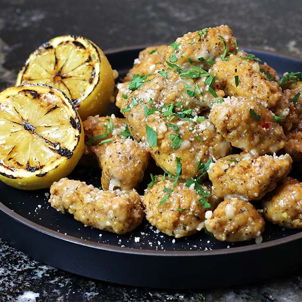 Boneless wings topped with parmesan garlic sauce, lemon juice, and chopped parsley