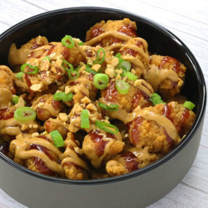Popcorn chicken topped with peanut butter, jelly, crunched peanuts, and green onion