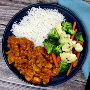 A bowl with rice, chicken, and vegetables