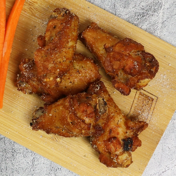 Salt and Vinegar wings on a cutting board with ranch and veggies
