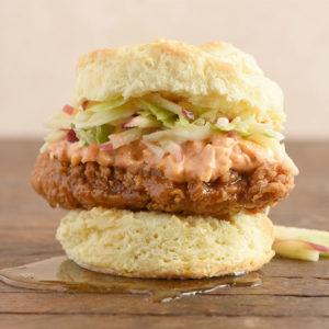 Chicken filet on a biscuit with pimento cheese, honey, and coleslaw