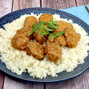 A plate with white rice topped with sticky miso boneless wings