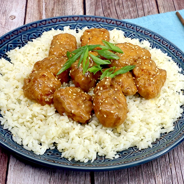 A plate with white rice topped with sticky miso boneless wings