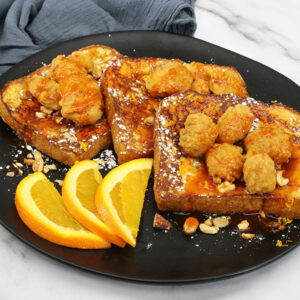 French toast topped with popcorn chicken and orange honey sriracha sauce