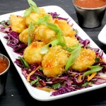 Tempura wings atop Asian-style slaw