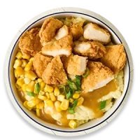 A mashed potato bowl topped with corn, gravy, and sliced chicken tenders